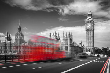 Fototapeta na wymiar Red double decker bus with motion blur on Westminster bridge, Big Ben in the background, in London, UK. Black and white with selective color