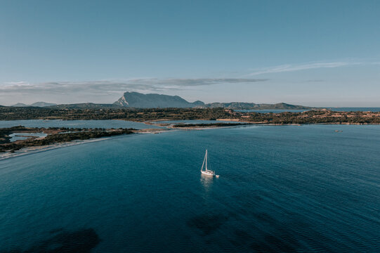 Segelboot liegt in der Bucht von sch&ouml;nen Strand La Cinta in San Teodoro auf der Insel Sardinien. Sonneruntergang und Tavolara Drone 1