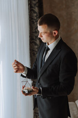 wedding rings in the hands of an adult man decorated in a glass box and various flowers