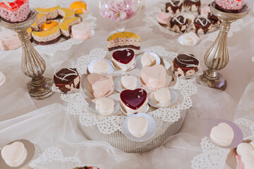 Obraz na płótnie Canvas Festive dessert table with sweets. Wedding candy bar, various cakes, chocolates on stands.