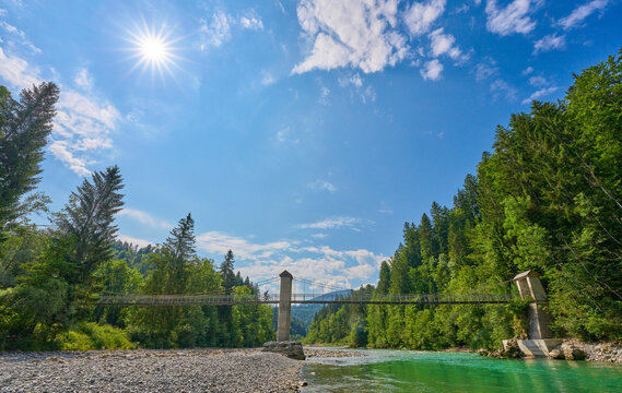 Woman crossing sudpension bridge over Bregenzer Aach River in the Bregenz Forest mountains, Vorarlberg, Austria