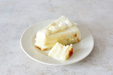 slice of creamy coconut cake on white saucer, close up
