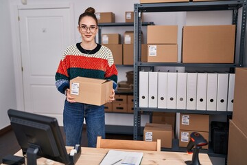 Fototapeta na wymiar Young woman ecommerce business worker holding package at office
