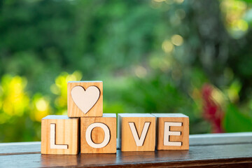 close de cubos de madeira que juntos formam a palavra love e mais um cubo com um coração...
