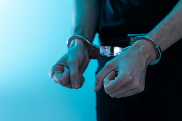 Young man desperate to catch the iron prison,prisoner concept,Handcuffed hands of a prisoner in...