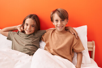Obraz na płótnie Canvas Adorable boys hugging each other sitting on sofa at bedroom