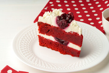 Piece of red velvet cake on white table