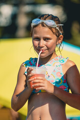 Little girl drinking cocktail in aquapark