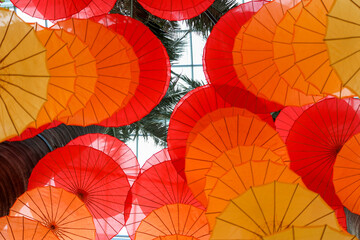 Fototapeta na wymiar hanging paper umbrella used as decorative spread and looks like wind-chimes, orange and yellow in color. top up view