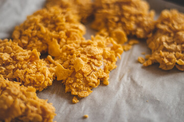 Slices of natural organic chicken cutlet coated in egg and cornflakes to create the perfect crispy strips