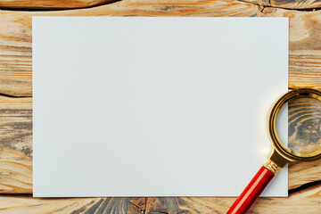 Magnifying glass on old paper on dark brown wooden backgorund