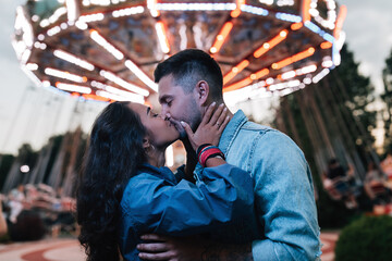 Young couple kissing in an amusement park at the evening © Artem Varnitsin