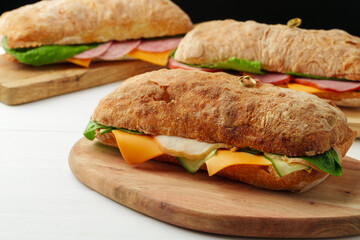 Chiabatta sandwich with ham and cheese on wooden board