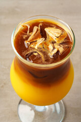 Coffee cocktail with orange juice and ice in glass