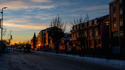Facade of typical Reykjavik houses illuminated by the last rays of the evening sun reflecting the...