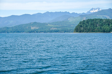 Ocean view from a boat at Puget Sound, state of Washington, USA. Scenic view of water, mountains, beach.