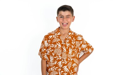 Little hispanic boy wearing  hawaiian shirt  winking looking at the camera with sexy expression,...