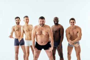 multiethnic men posing for a male edition body positive beauty set showing messages on banners....