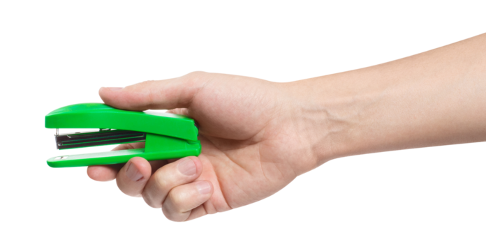 Hand holding a green stapler, cut out
