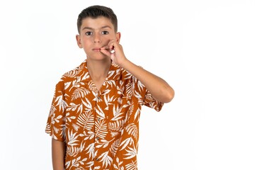 Little hispanic boy wearing  hawaiian shirt  mouth and lips shut as zip with fingers. Secret and...
