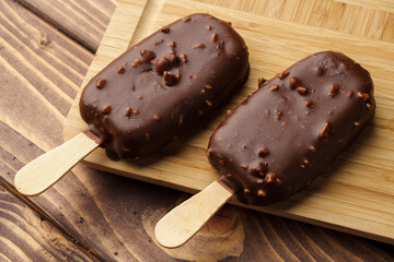 Chocolate cake pops ice creams on wooden board close up