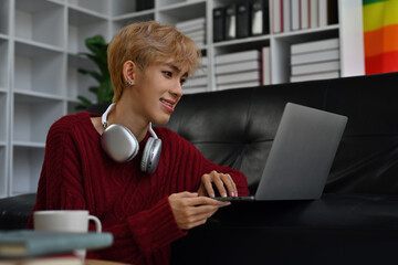 Portrait with Young Asian gay teenager learning online class with laptop, self study at home concept.