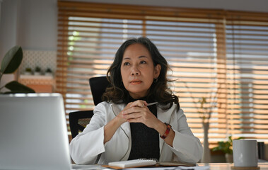 Portrait with Professional elderly Asian business woman working with laptop in the modern office.