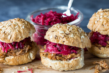 Healthy pulled pork buns topped with pickled beet and red cabbage sauerkraut.
