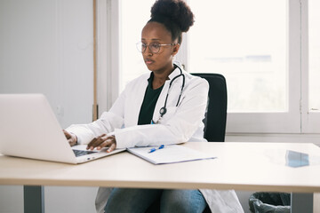 African American physician working on laptop