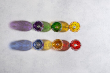 Colorful goblets and their falling shadows on a white background