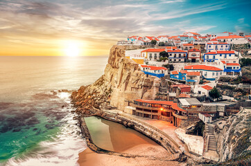 Azinheiras do Mar beach, fishing village with colorful houses of fishermen at sunset in Azenhas do Mar, Colares, Sintra, Portugal.