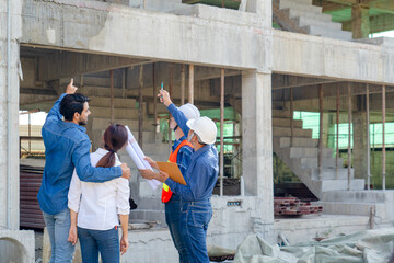 engineer or architect explain house renovation design to young couple owner while inspecting...
