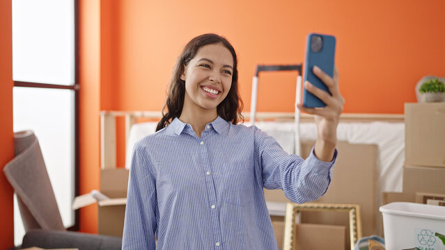 Young beautiful hispanic woman smiling confident make selfie with smartphone at new home