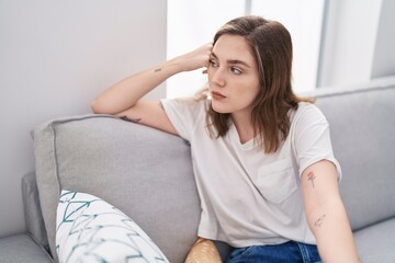 Naklejka premium Young woman stressed sitting on sofa at home