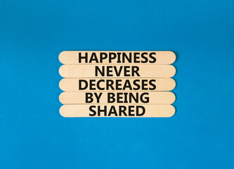 Happiness symbol. Concept words Happiness never decreases by being shared on wooden stick. Beautiful blue table blue background. Motivational Happiness concept. Copy space.