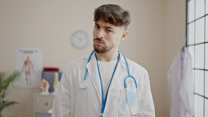 Young arab man doctor standing with angry expression at clinic