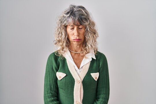 Middle age woman standing over white background depressed and worry for distress, crying angry and afraid. sad expression.