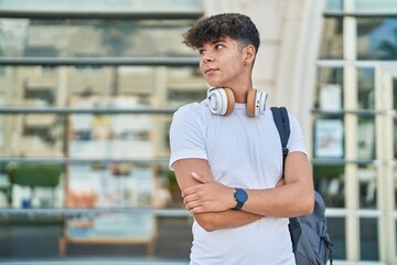 Young hispanic teenager student smiling confident standing with arms crossed gesture at university