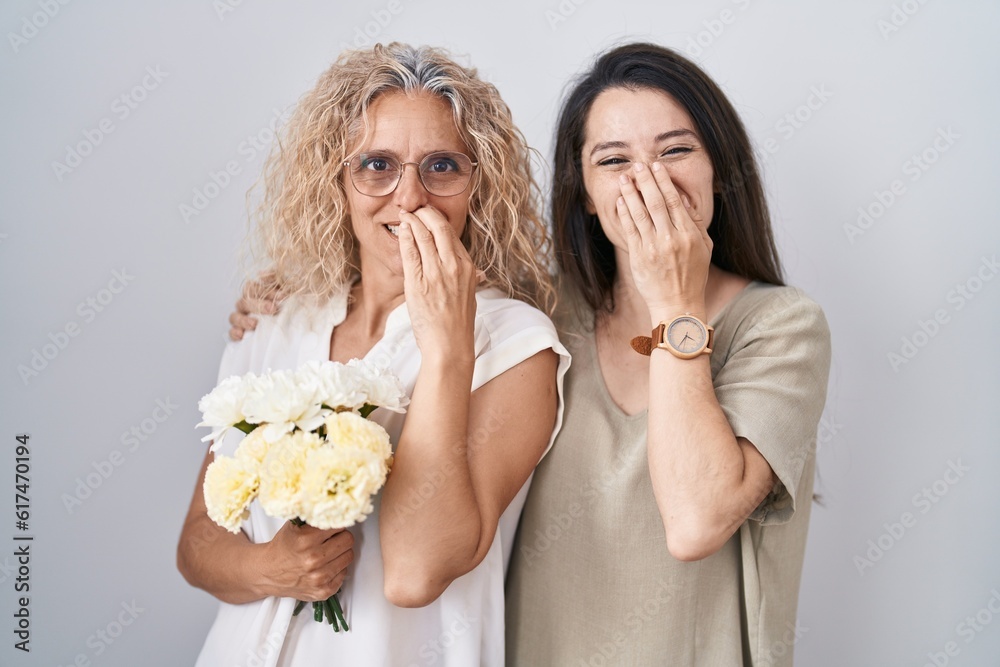 Sticker Mother and daughter holding bouquet of white flowers laughing and embarrassed giggle covering mouth with hands, gossip and scandal concept