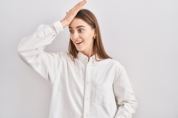 Obraz premium Young caucasian woman standing over isolated background surprised with hand on head for mistake, remember error. forgot, bad memory concept.