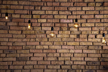 Old electric incandescent lamps with tungsten filament. Against the backdrop of a brick wall....