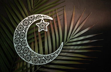 Crescent moon shape on green leaf with copy space for greeting text, Eid Al Adha and Ramadan Mubarak concept Islamic background