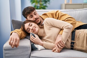 Mand and woman couple lying on sofa sleeping at home
