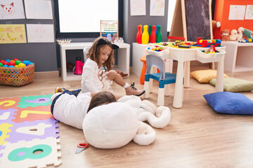 Adorable boy and girl students sitting on table smiling confident at kindergarten