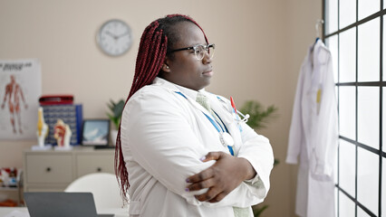 African woman with braided hair doctor looking though the window standing at clinic
