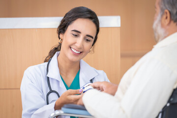 Professional Medical Doctor diagnosing and giving advice to the elderly patient at hospital.