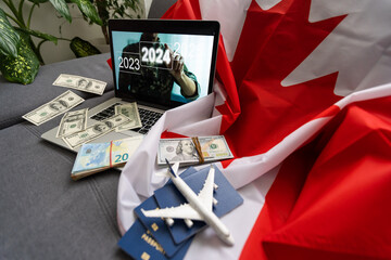 laptop with travel, money and canada flag