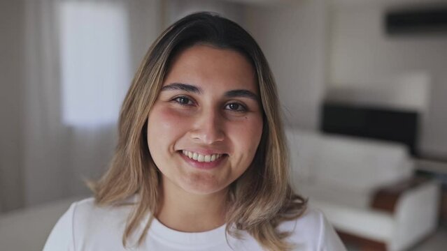 Confident smiling confident young caucasian woman pretty face looking at camera posing alone at home in office, happy millennial girl professional close up front portrait. 