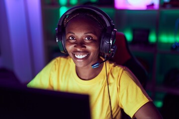 African american woman streamer smiling confident sitting on table at gaming room