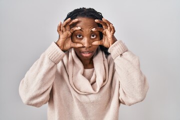 African woman standing over white background trying to open eyes with fingers, sleepy and tired for morning fatigue